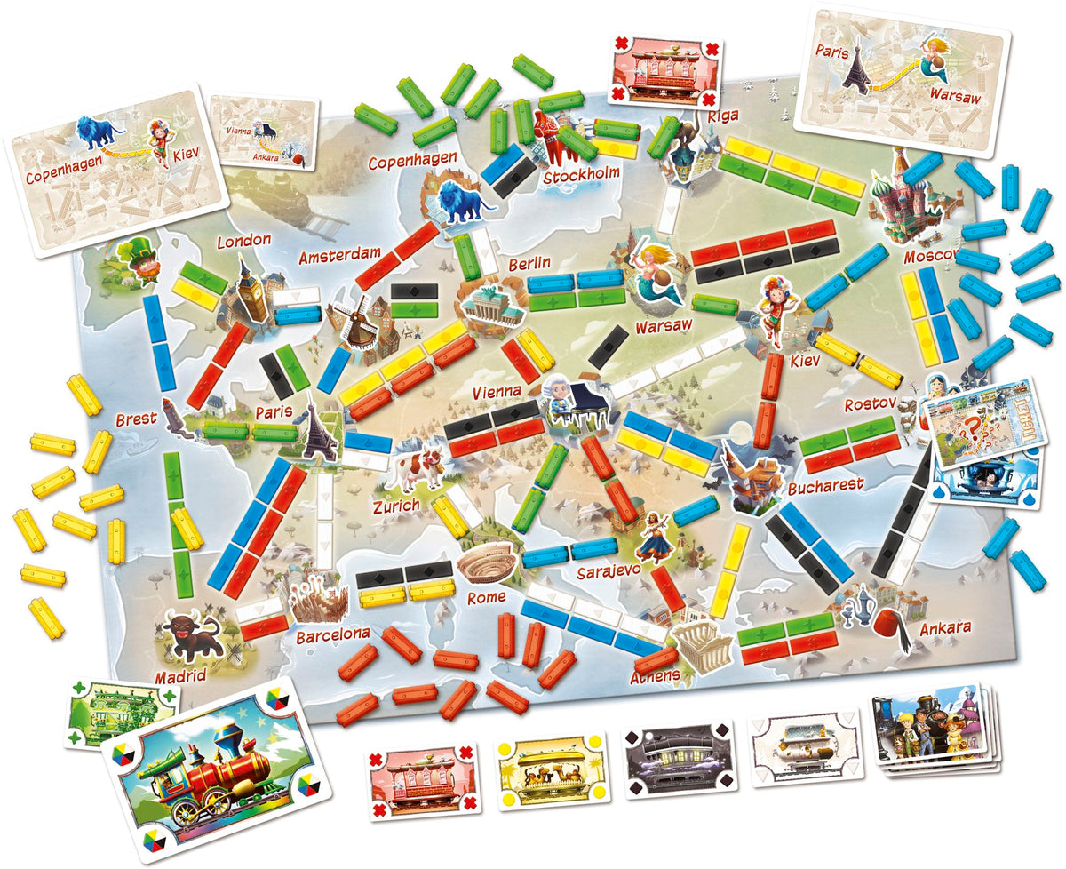 The board game 'ticket to ride first journeys' shown with its components, including the illustrated world map board, player cards, train cards, and tokens, arranged on a clean white background.