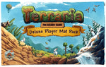 Front cover artwork for the Terraria The Board Game Deluxe Player Mat Pack, featuring a colorful illustrated landscape with mountains, trees, a waterfall, penguins, and the product title in large grassy letters.